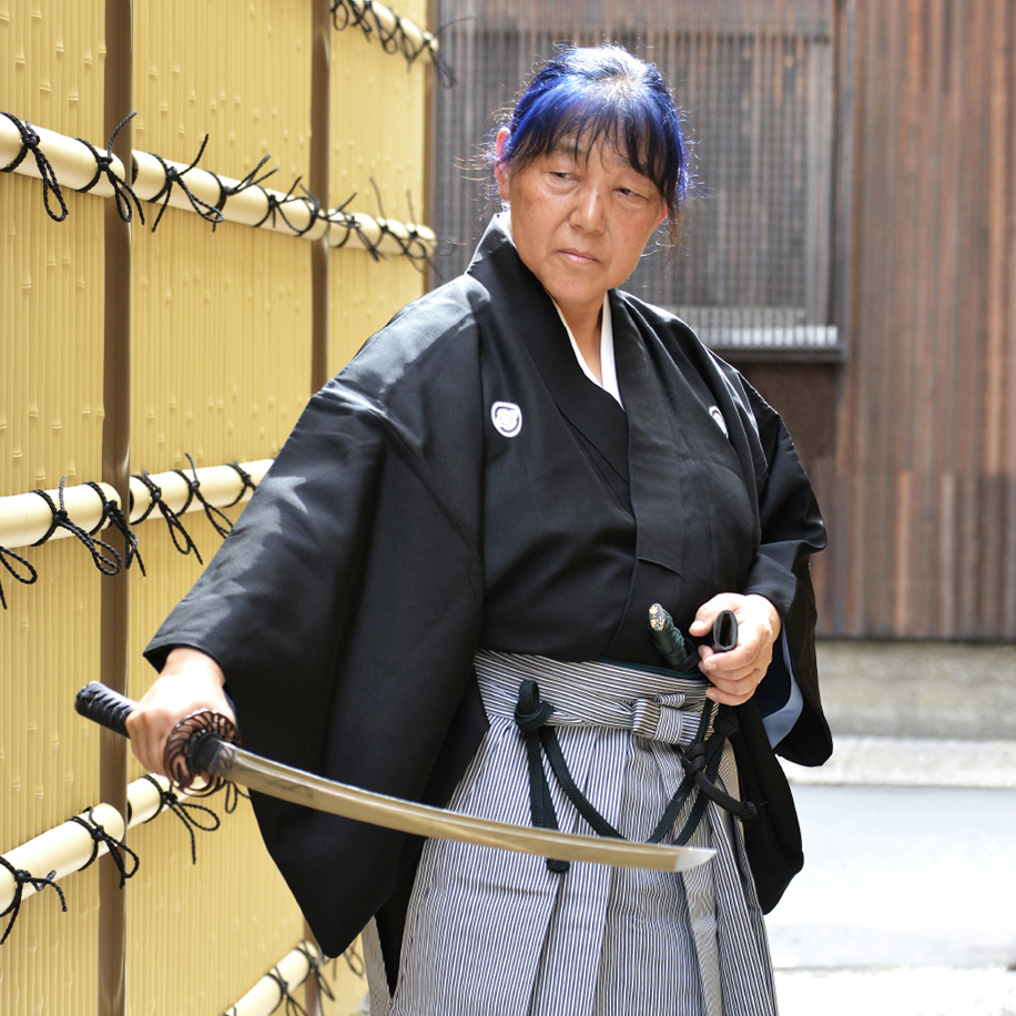 竹垣の小径で模擬刀を構える佐藤里香錬士