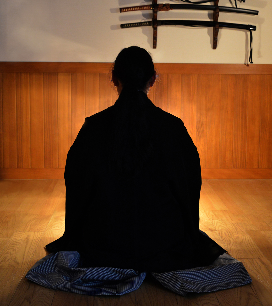 刀掛けの前で正座し、後ろ姿で静かに向き合う戸山流誠斬会の稽古風景